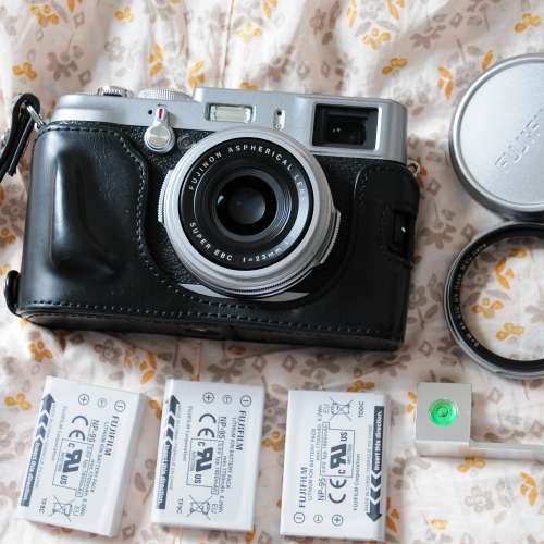 Fujifilm X100 + 3 original batteries , leather case, B+W filter & thumb grip .