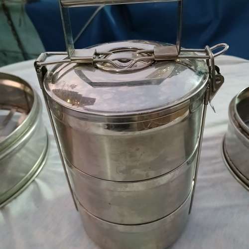 一套不銹鋼三層飯盒及二個蒸籠，共售150元。no.DR5.1.25