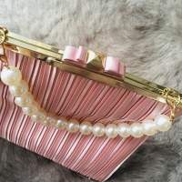Pleated silk clutch with knotted bow