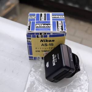 這是一個 Nikon AS-15 同步終端轉接器（Sync Terminal Adapter），用於將相機的熱靴...